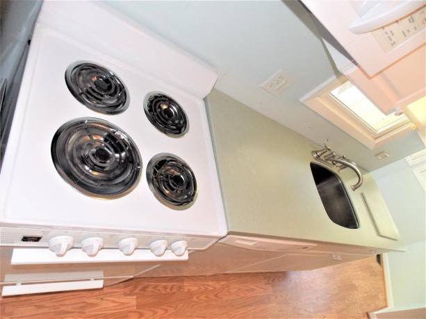 white-kitchen-cabinets-with-corian-counter-and-all-appliances-big-1