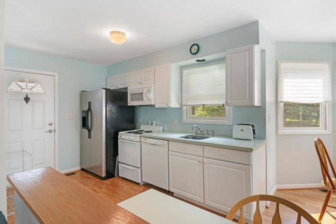 white-kitchen-cabinets-with-corian-counter-and-all-appliances-big-4