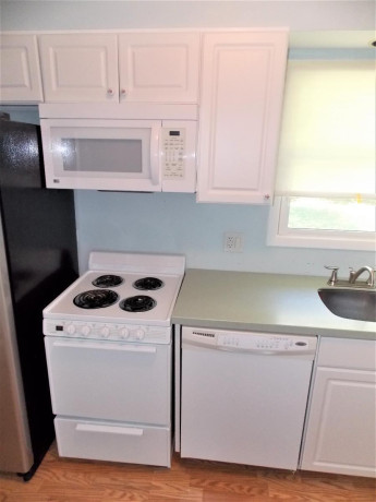 white-kitchen-cabinets-with-corian-counter-and-all-appliances-big-2