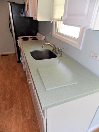 white-kitchen-cabinets-with-corian-counter-and-all-appliances-big-0