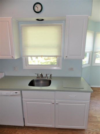 white-kitchen-cabinets-with-corian-counter-and-all-appliances-big-3